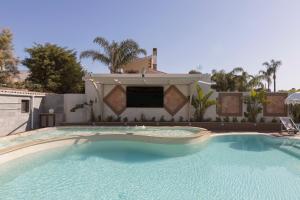 a large swimming pool in front of a house at Aqua Suites Doria in Syracuse
