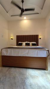 a bedroom with a large bed with a ceiling fan at Sahil Private Pool Villa in Alibaug +5 photos