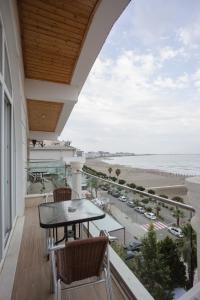 a balcony with a table and chairs and a view of the beach at Trevi Hotel & Restorant, Shengjin in Shëngjin