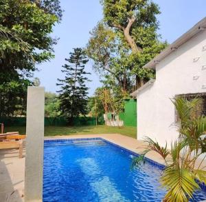 a swimming pool in front of a house at Sahil Private Pool Villa in Alibaug