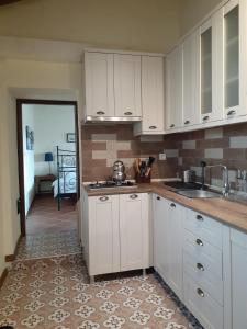 a kitchen with white cabinets and a sink and a counter at The Gallipoli Houses in Eceabat +35 photos