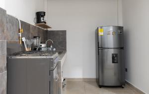 a kitchen with a stainless steel refrigerator and a stove at Habitación con baño privado en Circasia Quindío in Circasia