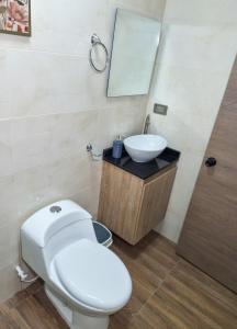 a bathroom with a white toilet and a sink at Habitación con baño privado en Circasia Quindío in Circasia