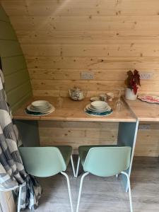 a wooden table with two chairs and plates on it at Pennygael in Lanark