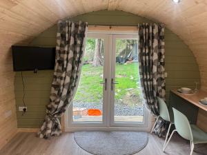 a room with a door and a window with curtains at Pennygael in Lanark