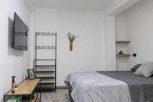 a bedroom with a bed and a tv and a table at Habitación con baño privado en Circasia Quindío in Circasia