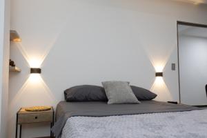 a bedroom with a bed with two lights on it at Habitación con baño privado en Circasia Quindío in Circasia