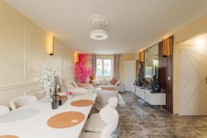 a living room with white furniture and a television at Villa layra Havre de paix Haute de Gamme in Goussainville
