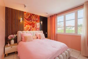 a bedroom with a large white bed with pink pillows at Villa layra Havre de paix Haute de Gamme in Goussainville