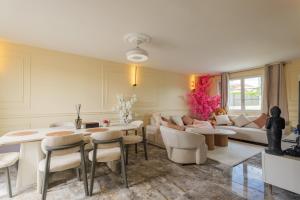 a living room with a couch and a table and chairs at Villa layra Havre de paix Haute de Gamme in Goussainville