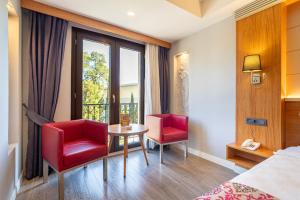 a hotel room with a table and two red chairs at May park HOTEL in İzmir