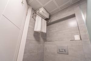 a bathroom with a shower with white towels at May park HOTEL in İzmir +35 photos