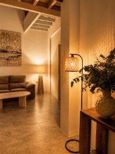 a living room with a couch and a table with a plant at Arena House Conil in Conil de la Frontera