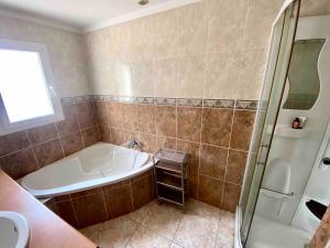 a bathroom with a tub and a shower and a sink at Large Family Chalet Mountain Views in Olette +6 photos