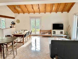 a living room with a table and chairs and a tv at Large Family Chalet Mountain Views in Olette