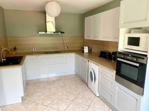 a kitchen with white cabinets and a washer and dryer at Large Family Chalet Mountain Views in Olette