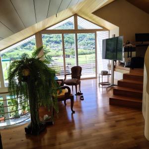 a living room with a large window and a chair at BluVilla in Malvaglia