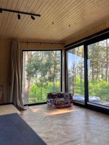 a living room with a couch and large windows at Connect Cabin - Bungalow Brasov, jacuzzi & forest view in Purcăreni