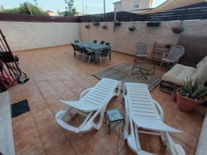 a patio with two white chairs and a table and chairs at Apartment with terrace in Vinarós
