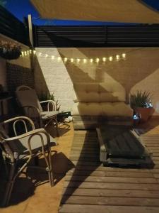 a patio with a couch and chairs and lights at Apartment with terrace in Vinarós +19 photos
