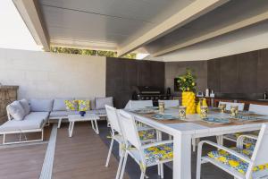 a patio with a table and chairs and a couch at Aqua Suites Doria in Syracuse