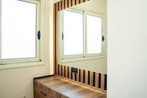 ein Spiegel in einem Zimmer mit zwei Fenstern in der Unterkunft Hotel Vila Stefa in Vlorë