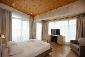 a bedroom with a bed and a tv and a couch at Trevi Hotel & Restorant, Shengjin in Shëngjin