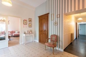 a living room with a chair and a couch at L'Apothicaire 2 Chambres - Piscine in Montaigu-Vendée +42 photos