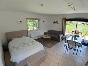 a bedroom with a bed and a couch and a table at L'annexe in Gouy