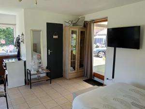a bedroom with a bed and a tv on the wall at L'annexe in Gouy