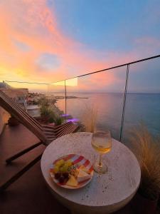 a table with a plate of food and a glass of wine at Ca' Mare luxury suite in Mesongi