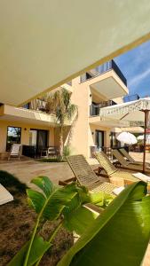 a resort with chairs and a building with palm trees at Palm Suites in Nea Vrasna