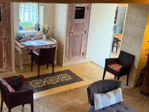 a living room with a table and chairs and a desk at Les Maisons d'Antan 5 étoiles in Saint-Geniès