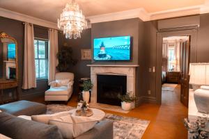 a living room with a fireplace and a tv at The Underwood-Hale House in Providence