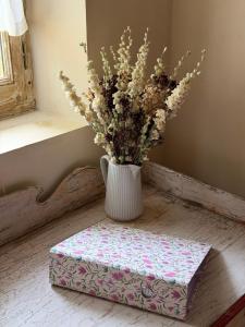 a vase with flowers sitting on top of a box at Les Maisons d'Antan 5 étoiles in Saint-Geniès +68 photos