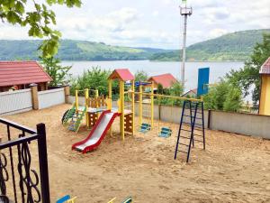 a playground with a slide in the sand at Вілія in Lomacineţi