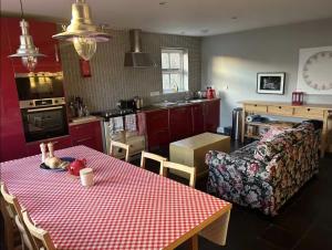 a living room with a table and a couch and a kitchen at Harris Cuckoo Cottage in Luskentyre