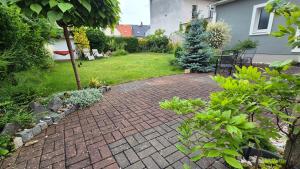 a garden with a brick walkway in a yard at Soukromý pokoj pro 2 se sdílenou koupelnou a kuchyni Bezručova in Hradec Králové