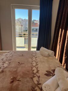a bedroom with a bed with towels and a window at Casa Marelia - studio A2 in Primošten