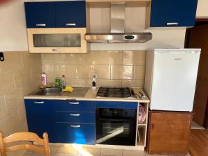 a kitchen with blue cabinets and a stove top oven at Casa Marelia - studio A2 in Primošten