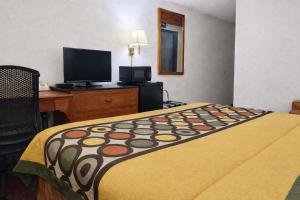 a hotel room with a bed and a flat screen tv at Algona Inn in Algona