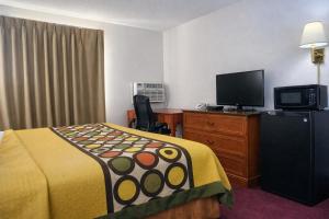 a hotel room with a bed and a flat screen tv at Algona Inn in Algona
