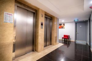 a hallway with doors and a red bench in a building at May park HOTEL in İzmir