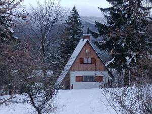a brown barn with a white garage in the snow at Chata Panorama in Čremošné +42 photos
