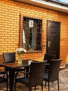 a table with chairs and a vase of flowers on it at Дом у Озера in Priozersk