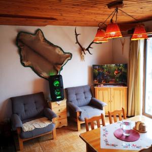 a living room with two chairs and a table at Chata Panorama in Čremošné