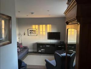 a living room with a couch and a tv at Harris Cuckoo Cottage in Luskentyre