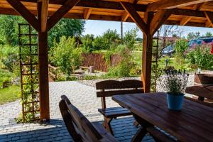 a wooden table and chairs on a patio at Domki Nad Satwem Mazury D2 in Mrągowo
