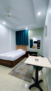 a bedroom with a bed and a table in it at Grand Hotel Qena in Qinā