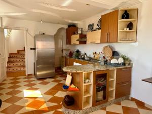 a kitchen with a refrigerator and a table in it at Tiri Hub in Tamraght Ouzdar